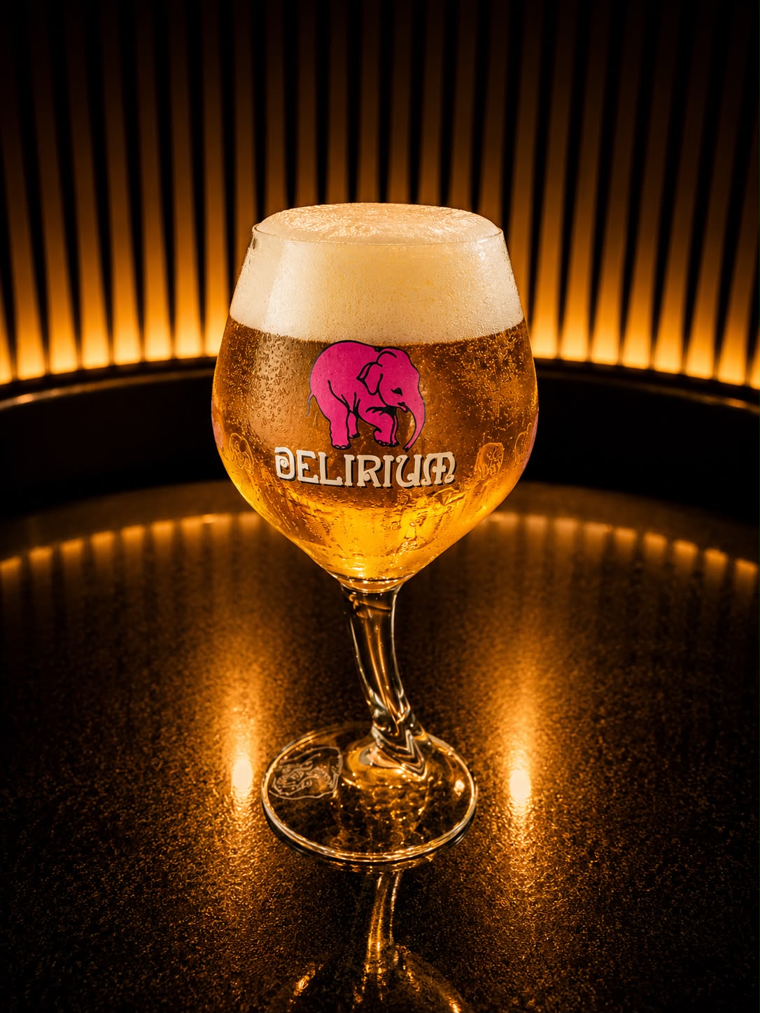 Une bière blonde à la mousse épaisse, servie dans un verre à pied Delirium